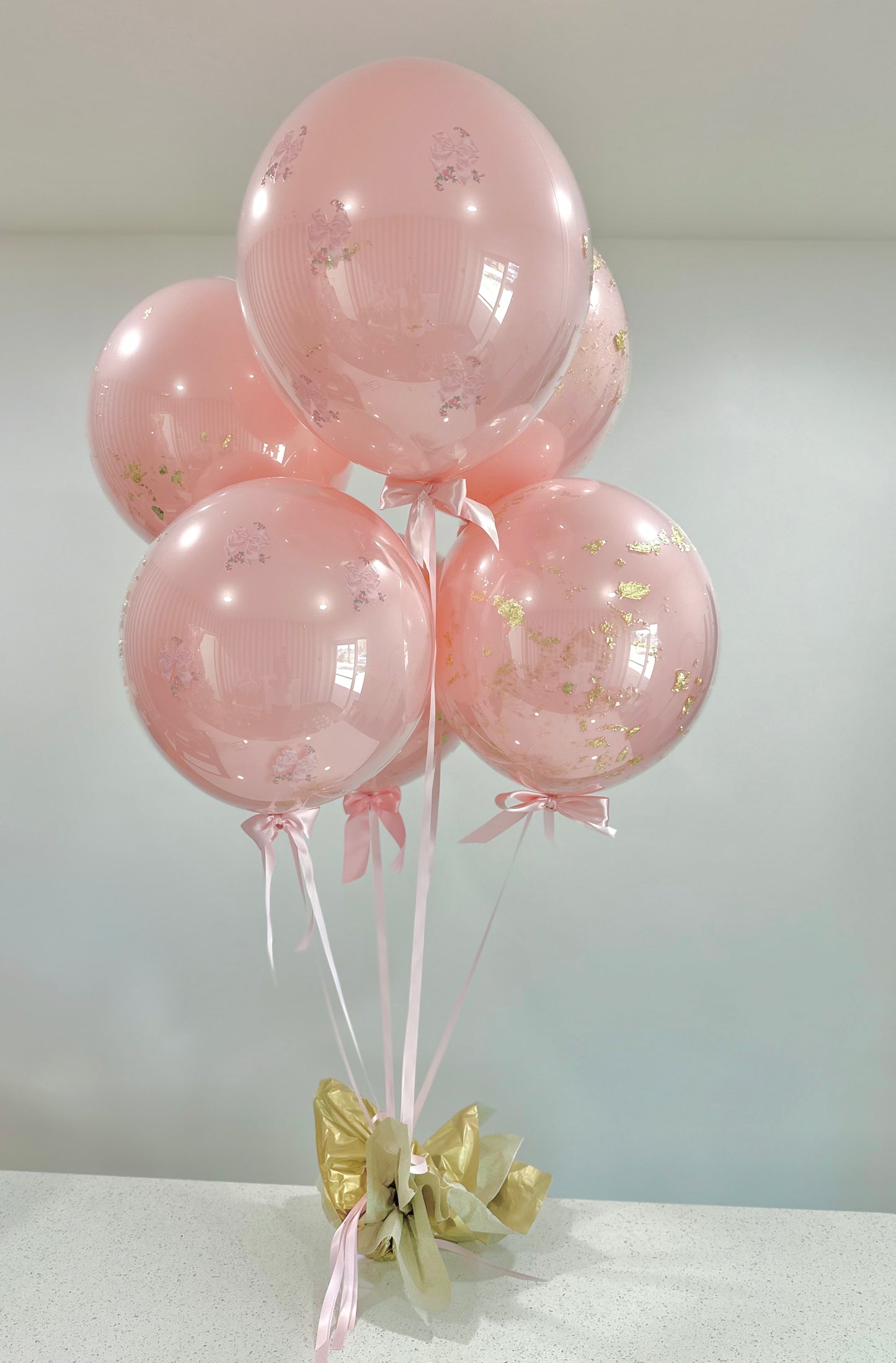 Pink transparent balloons with gold leaf and satin pink ribbon. Balloon Bouquet in Sarasota florida